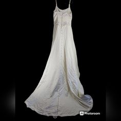 a white dress is hanging on a black background