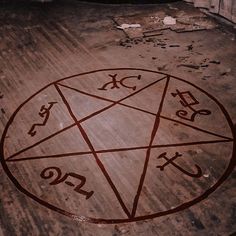 a pentagramus circle with numbers and symbols on the floor in an abandoned building