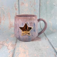 a ceramic mug with a gold star on it