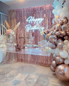 a birthday party setup with balloons, cake and confetti on the side table