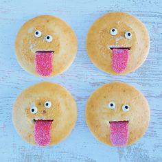 four donuts with faces painted on them and one has a pink tongue sticking out