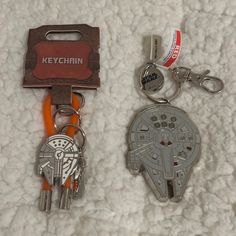 two keychains are laying next to each other on a white carpeted surface