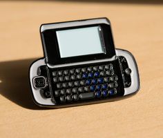 a small black and white cell phone sitting on top of a table