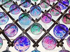 many different colored glass ornaments hanging on a wall