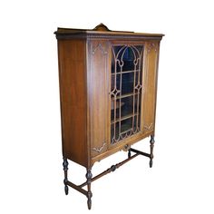 an old fashioned wooden cabinet with glass doors