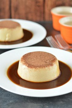 two white plates topped with desserts on top of a table