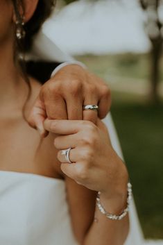 a bride holding the groom's wedding ring