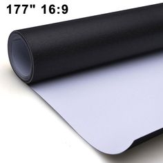 a roll of black and white paper on top of a table next to a ruler