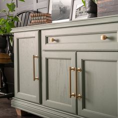 a green cabinet with brass handles and knobs in a living room or dining room