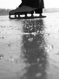 a black and white photo of someone's feet on the ground with raindrops