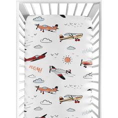 a white crib with airplanes and clouds on it