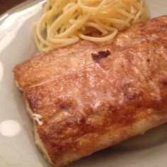 a white plate topped with meat and pasta