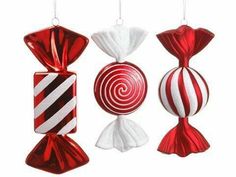 three red and white christmas ornaments hanging from strings with candy canes in the middle