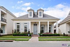 a white house with lots of windows and bushes