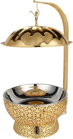 a gold and black bowl on a stand with a metal dome over it's head