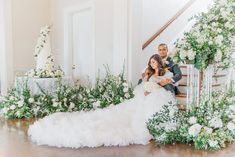 a bride and groom sitting on the stairs at their wedding