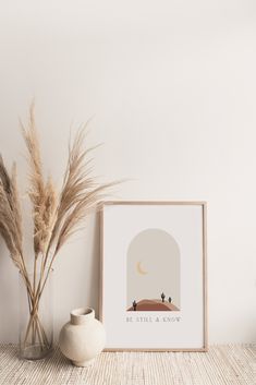 there is a vase and some plants on the table next to a framed print that says little & know