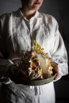 a woman holding a plate with a cake on it