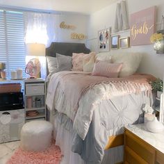 a bedroom with pink and white decor on the walls