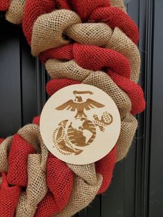 a marine wreath with the emblem of an eagle, fish and globe is hanging on a door