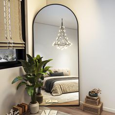 a bedroom with a large mirror on the wall next to a potted plant and lamp