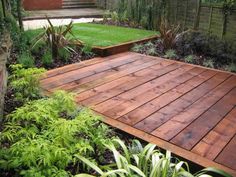 a wooden deck surrounded by plants and trees