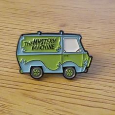 a green and blue van with the mystery machine written on it sitting on a wooden table