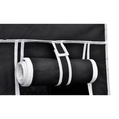 two rolls of black and white fabric hanging from the side of a bag with straps on it