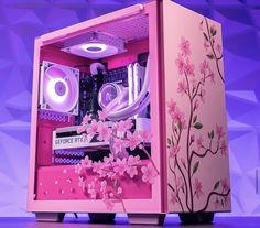 a pink computer case sitting on top of a purple surface with flowers in the front