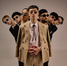 a group of young men standing next to each other in front of a white background