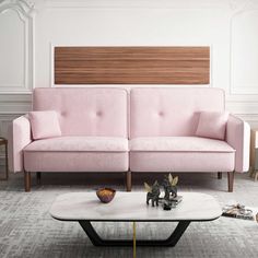 a living room with two pink couches and a coffee table in front of it