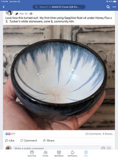 a hand holding a black and white bowl