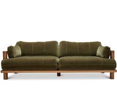 a green velvet couch with wooden legs and arm rests on an isolated white background,