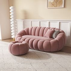 a pink couch sitting on top of a white rug