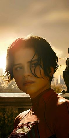 a woman with her hair blowing in the wind, wearing a red shirt and headphones