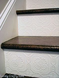 a wooden shelf sitting on the side of a white wall next to a stair case