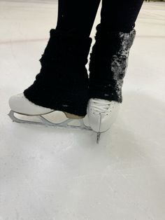 the feet of a person skating on an ice rink