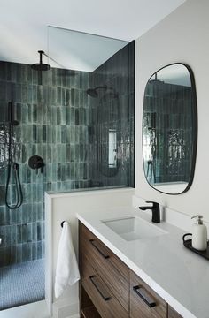 a bathroom with two sinks, mirrors and a shower stall in it's corner