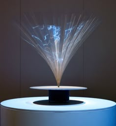 a white table topped with a blue vase filled with water and lightening up the top