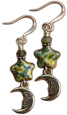 pair of earrings with moon and crescent design on them, hanging from silver earwires