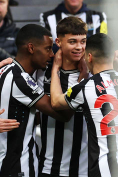 three soccer players are congratulating each other in the middle of a group hug