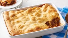 a casserole dish with meat in it on a blue and white checkered table cloth