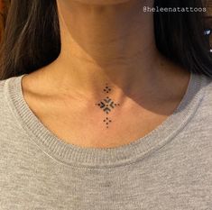 a woman's neck with a small cross tattoo on her left side ribcage