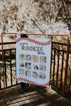 a sign that is on the side of a wooden fence with pictures hanging from it