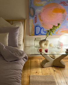 a bedroom with a glass table and white bedding