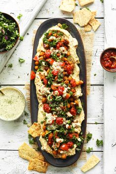 an oval platter filled with bread, tomatoes and spinach garnished with parmesan cheese