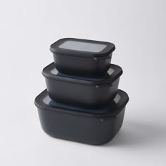 three black plastic containers stacked on top of each other with one container in the middle