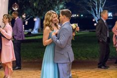 a man and woman standing next to each other on a dance floor