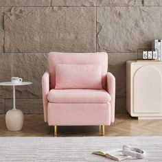 a pink chair sitting in front of a stone wall