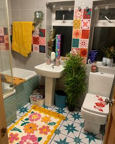 a bathroom with colorful tiles on the floor and walls